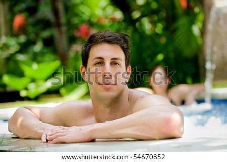 An attractive caucasian man relaxing in a jacuzzi pool outdoors
