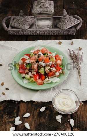 Full plate of vegetable salad in light plate on dark wooden table