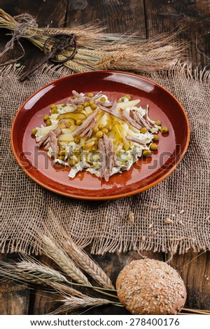 Rustic styling salad in dark plate on wooden table