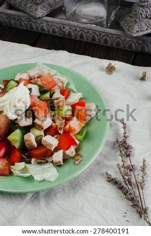Full plate of vegetable salad in light plate on dark wooden table