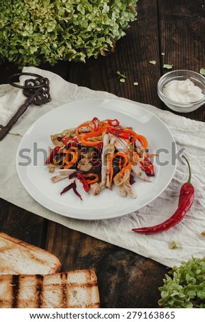 Vegetable salad with meet in white plate on dark table