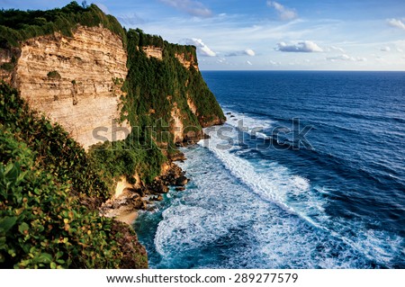 seascape with green rocks and huge wave cliffs