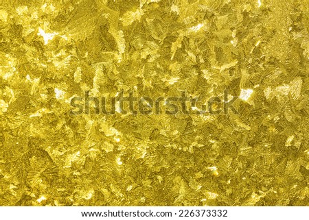 abstract holidays shiny gold  yellow background from a frosty pattern on glass