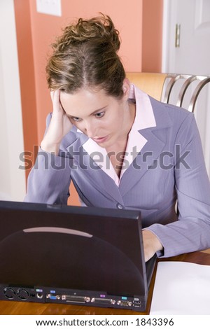 A young woman in business suit looking stressed working from home