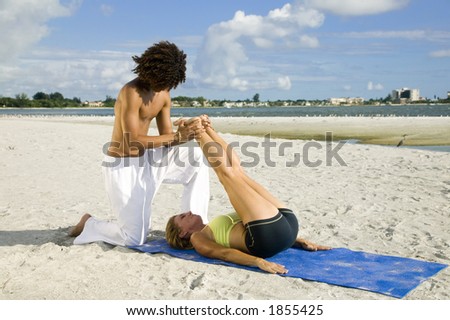 An attractive young couple works out on the beach