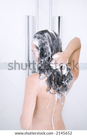 attractive young asian woman washes her hair in the shower