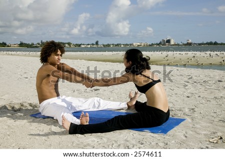 An attractive young couple works out on the beach