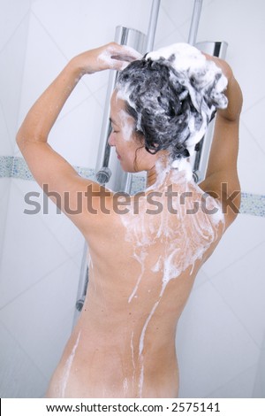 attractive young asian woman washes her hair in the shower