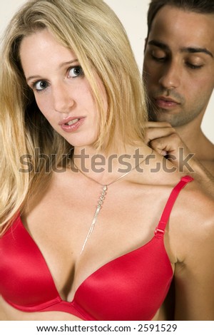 A young man puts and expensive necklace around a very attractive young womans neck!