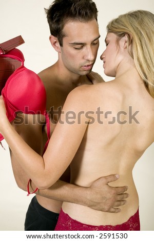 attractive, young, sexy caucasian couple making out against a white background