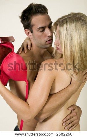attractive, young, sexy caucasian couple making out against a white background