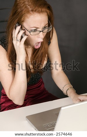 young red headed woman talking on cell phone and looking shocked