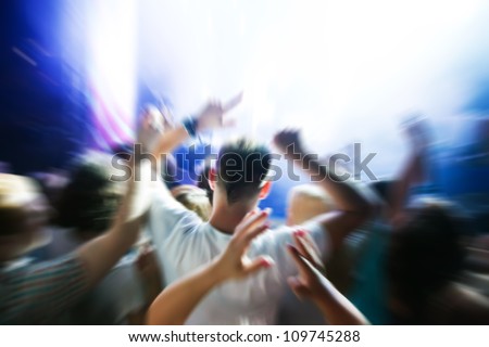 People with hands up having fun on a music concert / disco party.