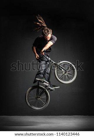 A man doing an extreme stunt on his BMX bicycle. Professional rider. Sport.