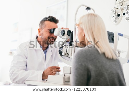 Optician examining woman\'s eyes with a machine. Eyesight care, doctor\'s appointment.