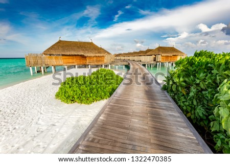 Wooden jetty and cabins on Maldives. Tropical holiday destination. Vacations and travelling.