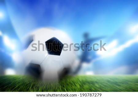 Football, soccer match. A player shooting on goal, ball in motion. Lights on the stadium at night.