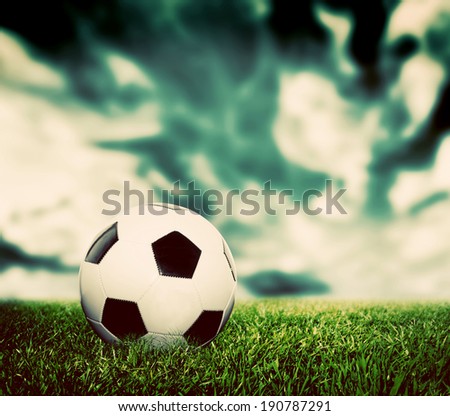 Football, soccer. A leather ball on grass, lawn. Dramatic sky, vintage, retro style