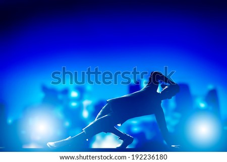 Hip hop, break dance performed by young man in city lights. Nightlife party time