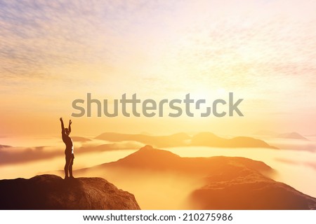 Happy man with hands up on the top of the world, above clouds and mountains. Success, winner, bright future
