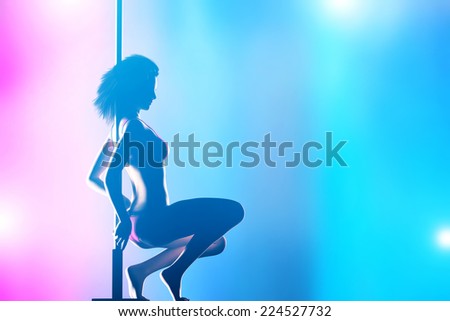 Woman performs sensual, passionate pole dance in night club. Sexy body silhouette, professional, sexual pose.