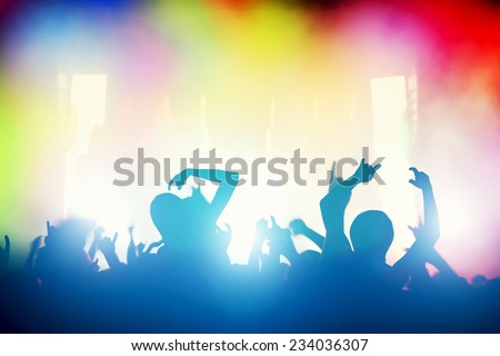 Concert, disco party. People with hands up having fun in night club lights