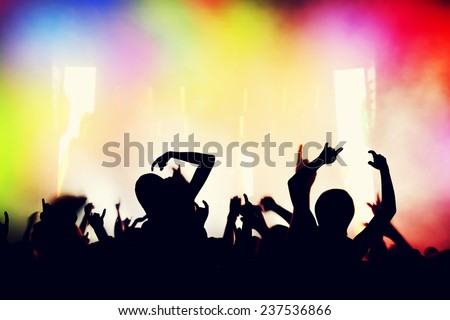Concert, disco party. People with hands up having fun in night club lights