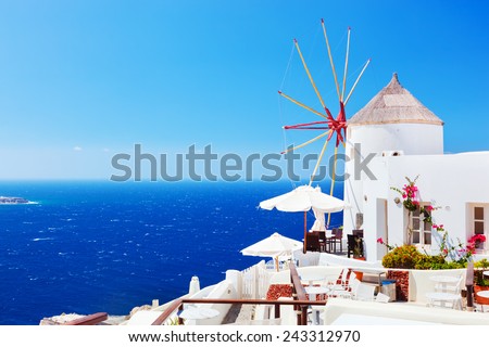 Oia town on Santorini island, Greece. Famous windmills on cliff over the Caldera, Aegean sea.