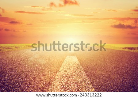 Long empty asphalt road towards sunset sun. Wide perspective, conceptual way