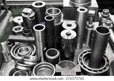 Industrial steel cylinders, pistons and tools in workshop. Industry theme.