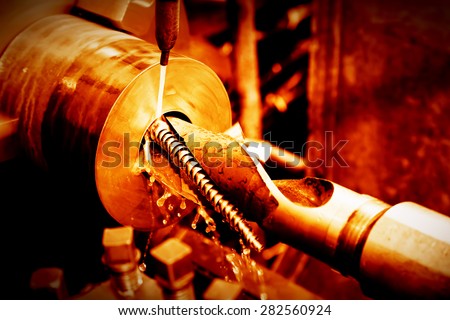 Industrial turning, threading machine at work close-up. Industry concept, red tone.