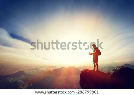 Man connecting with his smartphone on top of the mountain. Internet, communication, texting from remote place concepts.