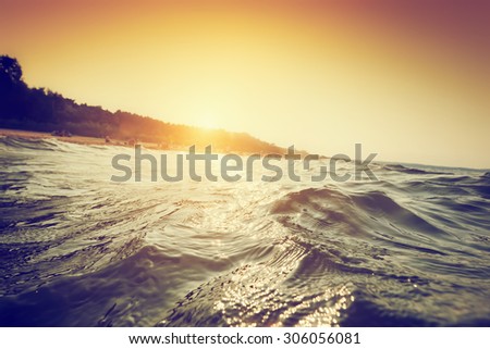 Sea waves and ripples at sunset. First person perspective swimming. Summer holidays, seaside.