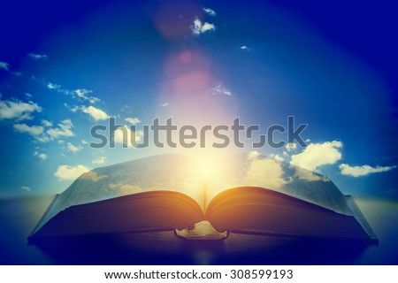 Open old book, light from the sky, heaven. Fantasy, imagination, education, religion concept.