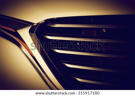 Modern luxury car close-up of grille. Gold background, concept of expensive, sports auto detailing