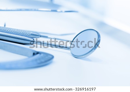 Equipment and dental instruments in dentist\'s office. Dental mirror, tools close-up. Dentistry. Blue tone