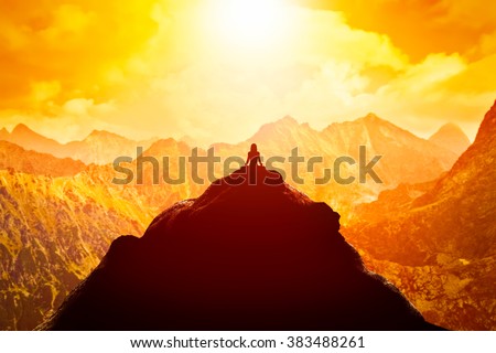 Woman meditating in sitting yoga position on the top of a mountains above clouds at sunset. Zen, meditation, peace