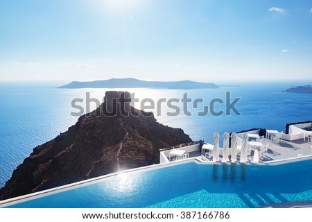 Swimming pool with a view on Caldera over Aegean sea, Santorini, Greece at hot sunny summer day.