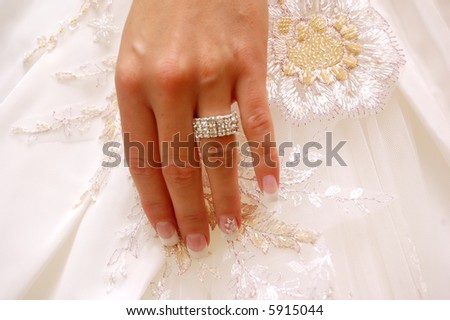 Wedding background. Bride\'s hand with ring on wedding gown