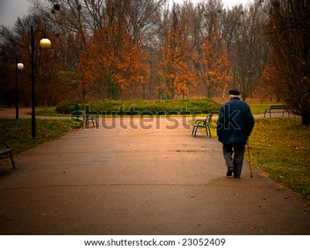 Old age concept. Man walks in autumn park
