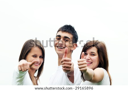 Three young happy friends laughing and giving okay sign