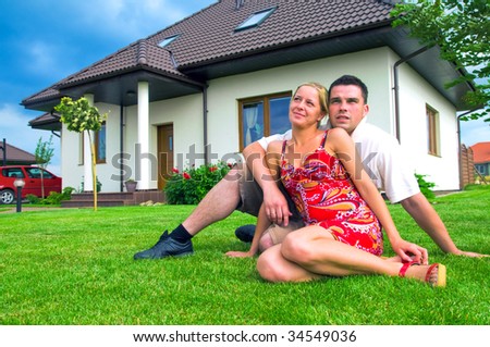 Happy couple in front of their ideal house