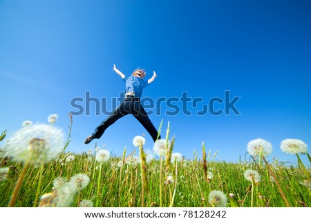 Young man jumping on the spring field. Freedom, success