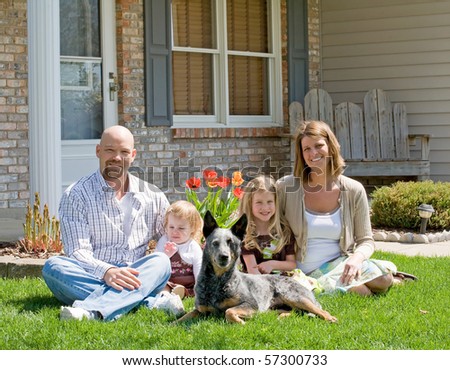 Family Sitting in Front of Their Home