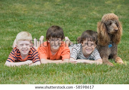 Three Boys Playing With Their Dog