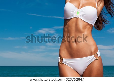 Young attractive girl enjoys hot summer day at the beach.