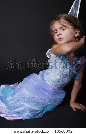 Beautiful little girl posing in good fairy costume with wings.