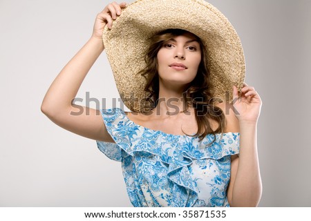 Young cute girl in blue fashion blue blouse and fancy hat.