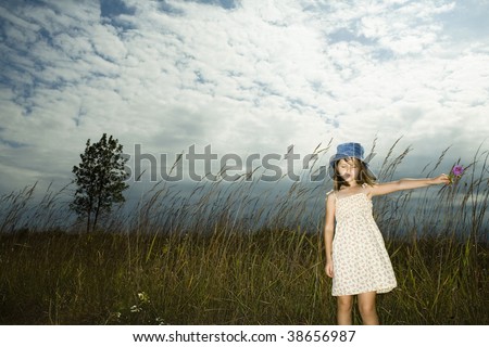 Little girl in short dress enjoys warm fall day.