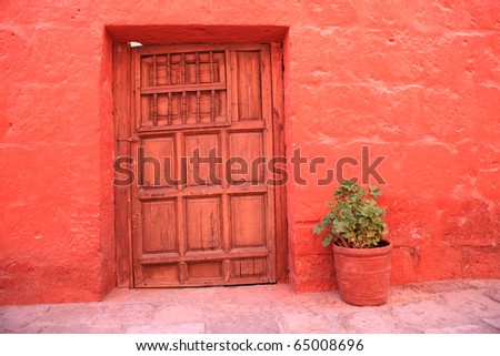 Vintage red wall with old decorative stone door.